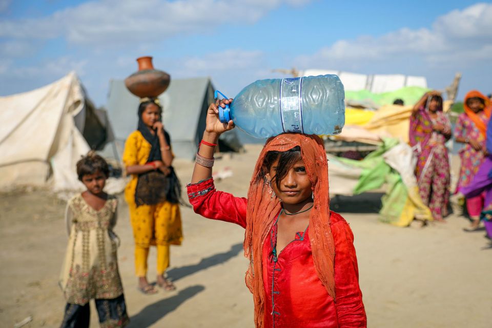 在巴基斯坦信德省一个被洪水淹没的村庄里，一个9岁的女孩在提水。