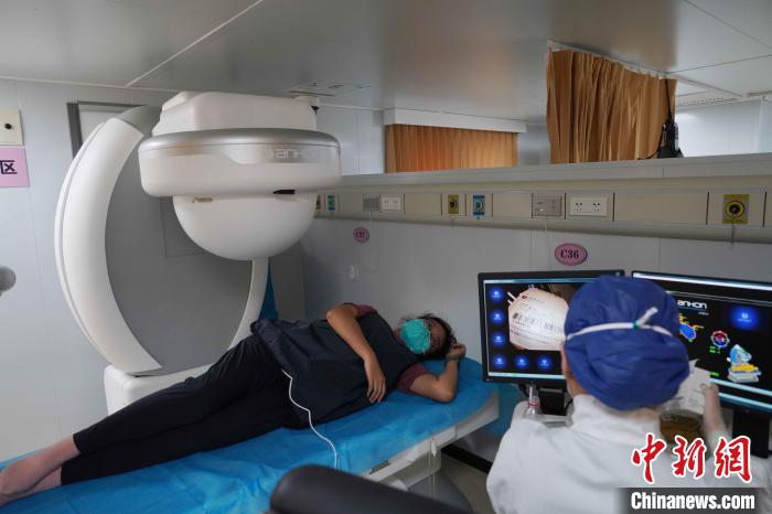 图为海上医院消化内科主治医师钱阳阳正在医院船上为一名当地民众做胶囊内镜检查。　孙飞 摄