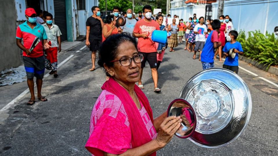 一名抗议食品价格上涨的妇女将菜肴放在一起。