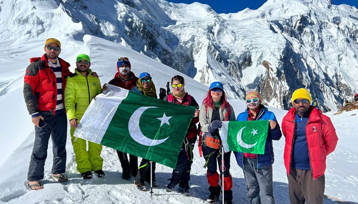 Pakistani adventurers and their team pose with the Pakistani flag after reaching Haramosh La. — Photo by author