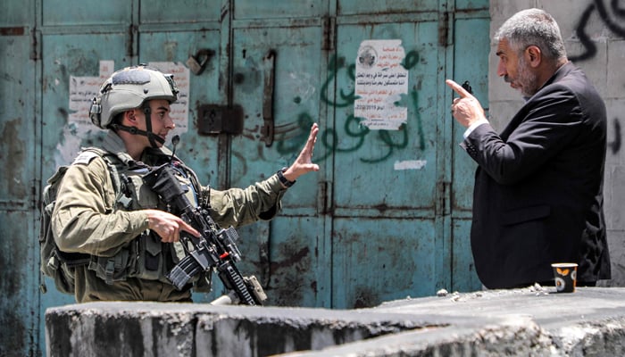 A Palestinian man argues with an Israeli soldier in the centre of Hebron in the occupied West Bank on July 4, 2023. — AFP