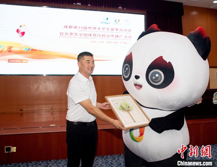 天津体育学院党委常委、副院长杨智接受成都大运会官方赠礼。　天津体育学院供图