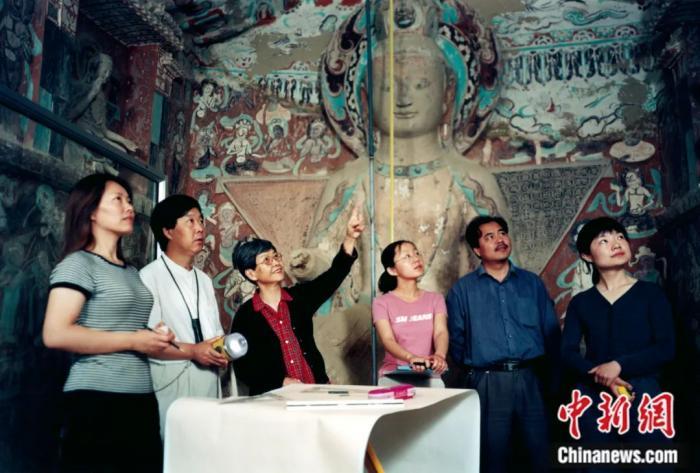 2004年，樊锦诗(左三)指导青年人研究工作。张伟文 摄