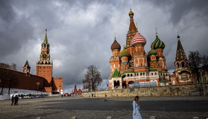 A woman walks near the Kremlin and St. Basils Cathedral in central Moscow, Russia, Feb. 22, 2022. AFP/File