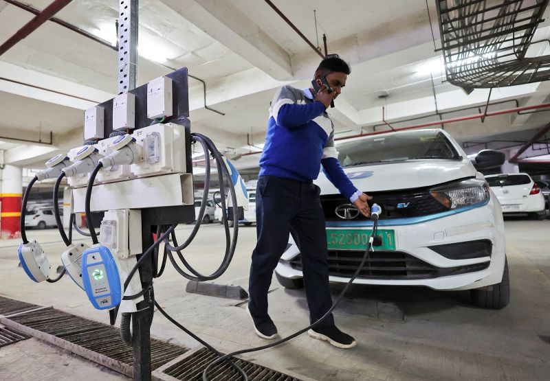 A man charging an EV at a BluSmart charging hub in Gurugram, India, in December 2022. BluSmart is an Indian ride-hailing startup that uses an all-electric fleet, relying heavily on charging infrastructure.