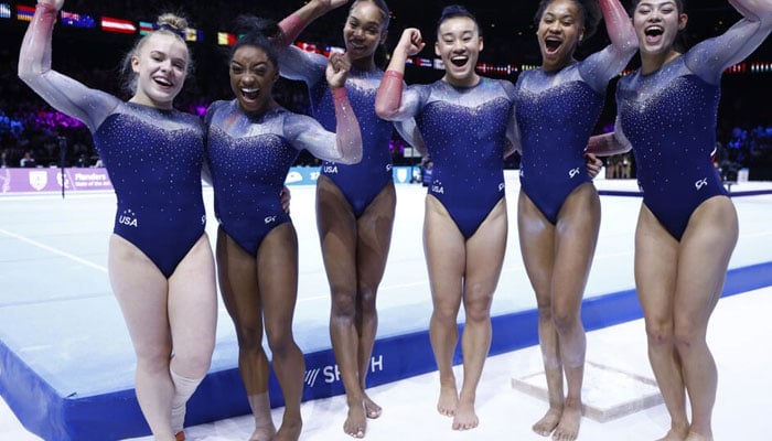 Simone Biles (2L) and her US team-mates celebrate a seventh straight team gold at the world championships in Antwerp. AFP