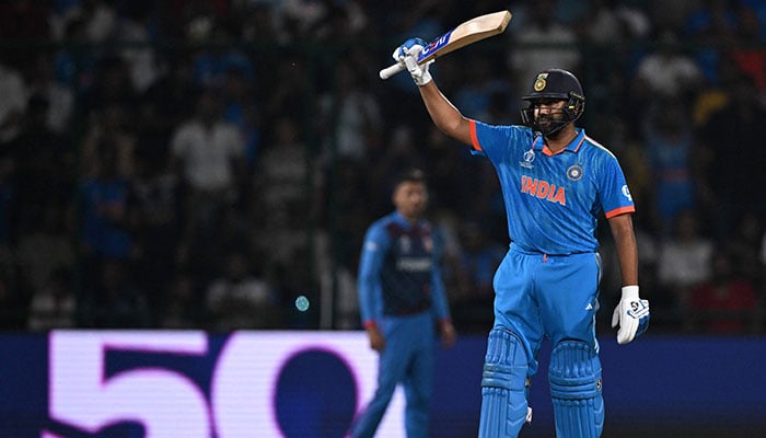 Indias captain Rohit Sharma celebrates after scoring a half-century (50 runs) during the 2023 ICC Mens Cricket World Cup one-day international (ODI) match between India and Afghanistan at the Arun Jaitley Stadium in New Delhi on October 11, 2023. — AFP