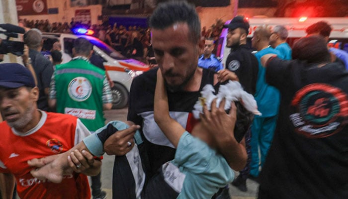 A Palestinian child injured in an Israeli air strike is carried inside the Nasser hospital in Khan Yunis in the southern of Gaza Strip, on October 17, 2023. AFP