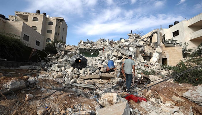 A man walks on the rubble of the home of Palestinian Bajis Nakhleh, who was detained two days ago by the Israeli military, after it was bulldozed by the Israeli army in Jalazone refugee camp, Ramallah on October 28, 2023. — AFP