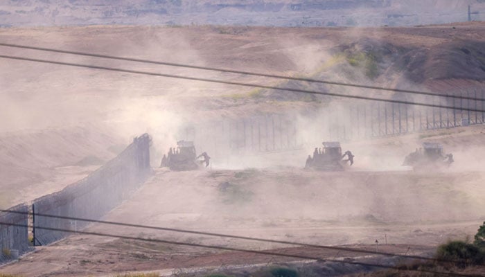 A picture taken from southern Israel along the border with the Gaza Strip shows Israeli army bulldozers crossing the border into Gaza, on October 29, 2023, amid ongoing battles between Israel and the Palestine. — AFP