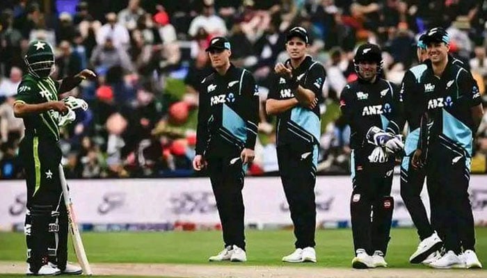 Babar Azam is seen standing at the pitch as New Zealand fielders look on. — AFP