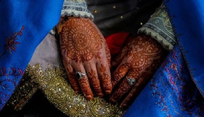 A representational image shows the hennaed hands of a bride. — AFP