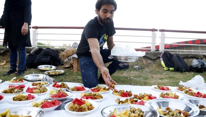 A man arranges food for Iftar at the roadside during the holy month of Ramadan in Islamabad. — Xinhua/File