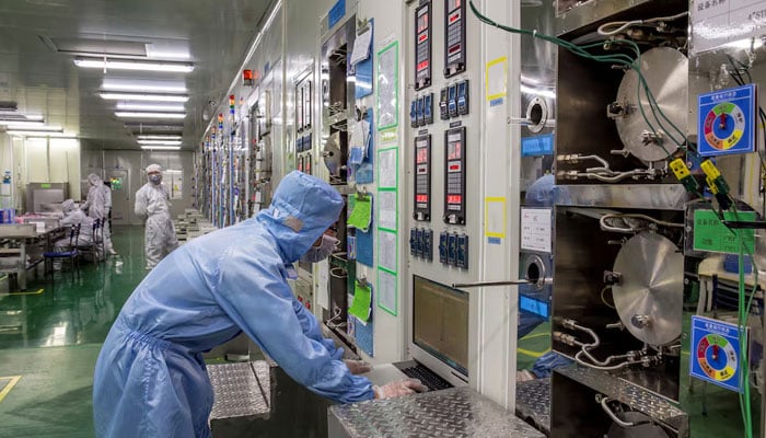 Employees work at a production line manufacturing chips inside a factory of an electronics company in Chizhou, Anhui province, China. — Reuters/File