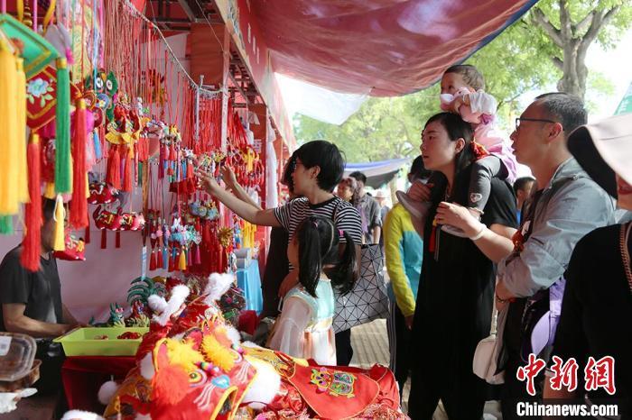 　6月7日，庆阳市民及游客在庆阳香包民俗文化展区选购文创产品。　盘小美 摄