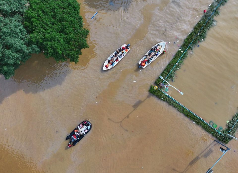 2024 年 6 月 20 日，无人机航拍照片显示，救援人员正在帮助当地居民从中国南部广西壮族自治区桂林市一条被洪水淹没的道路中撤离。自 6 月 9 日以来，中国南方许多地区遭遇强降雨，促使当地政府加强防洪和救援措施，以减少灾害损失。（新华社/黄小邦）