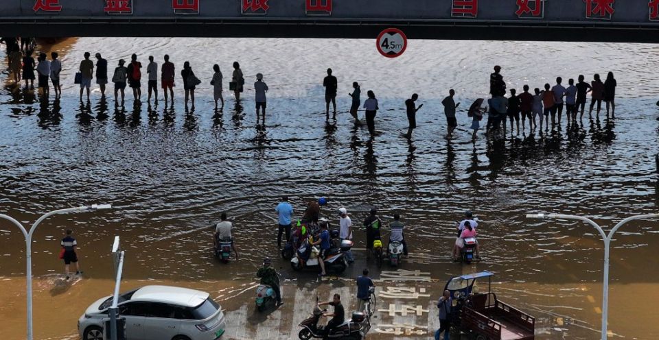2024 年 6 月 20 日，无人机航拍照片显示，居民在广西壮族自治区桂林市一条被洪水淹没的道路上等待撤离。自 6 月 9 日以来，中国南方许多地区遭遇强降雨，促使当地政府加强防洪抢险措施，以减少灾害损失。（新华社/黄小邦）