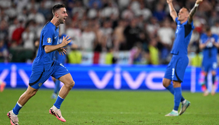 Slovenias forward #09 Andraz Sporar (L) celebrates qualifying for the knock-out stages on the pitch after the UEFA Euro 2024 Group C football match between England and Slovenia at the Cologne Stadium in Cologne on June 25, 2024. — AFP