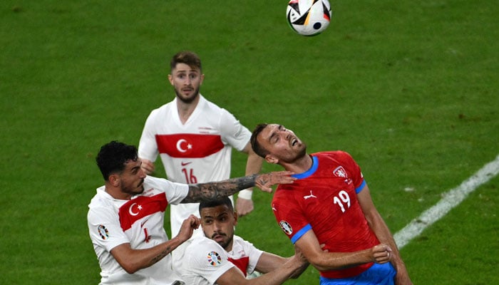 Czech Republics forward #19 Tomas Chory (R) heads the ball next to Turkeys defender #04 Samet Akaydin (L) during the UEFA Euro 2024 Group F football match between the Czech Republic and Turkey at the Volksparkstadion in Hamburg on June 26, 2024. — AFP