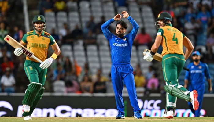 Afghanistans captain Rashid Khan (C) reacts as South Africas captain Aiden Markram (R) and South Africas Reeza Hendricks (L) run between wickets during the ICC mens Twenty20 World Cup 2024 semi-final cricket match between South Africa and Afghanistan at Brian Lara Cricket Academy in Tarouba, Trinidad and Tobago, on June 26, 2024. — AFP