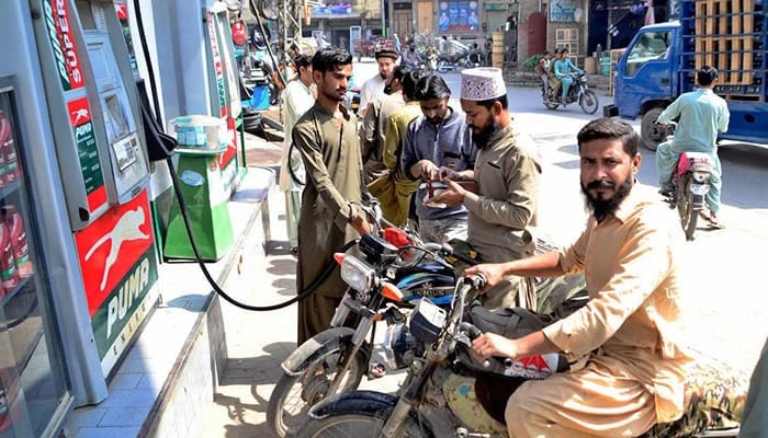 Motorcyclists filling their fuel tanks at a petrol pump in Hyderabad, on March 1, 2022. — APP