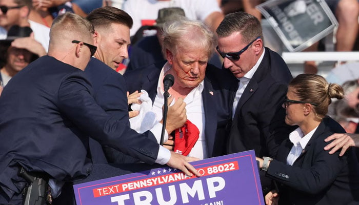 Former US president and Republican candidate for US election 2024 Donald Trump being assisted by Secret Service after an assassination attempt during his campaign rally in Butler, Pennsylvania, US on July 13, 2024. — Reuters